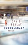 "DAVID SZALAY TURBULENZEN ROMAN" in großen Buchstaben. Verschwommene Szene eines Flughafens mit Menschen in Bewegung.