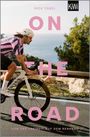 "ON THE ROAD. Von der Freiheit auf dem Rennrad." Ein Radfahrer auf einem Küstenweg, Meer im Hintergrund.