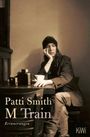 „Patti Smith M Train Erinnerungen“. Eine Frau sitzt nachdenklich an einem Tisch mit Kamera und Tasse. Subtile Farben.