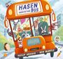 "Hasen rasen mit dem Bus", ein orangefarbener Bus voller fröhlicher Hasen, die wild aus den Fenstern schauen.