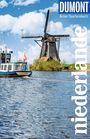 „DUMONT Reise-Taschenbuch Niederlande“. Windmühle, blauer Himmel, Boot im Wasser, niederländische Flagge.