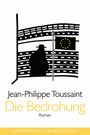 "Jean-Philippe Toussaint, Die Bedrohung, Roman". Silhouette eines Mannes vor dem EU-Gebäude mit Flagge.
