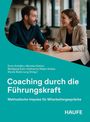 "Coaching durch die Führungskraft" steht in Weiß auf Türkis, darunter zwei Personen im Gespräch an einem Tisch.