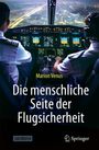 "Die menschliche Seite der Flugsicherheit" von Marion Venus. Zwei Piloten im Cockpit, städtische Lichter sind im Fenster zu sehen.