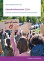 „Demokratiemonitor 2026“ zeigt Menschen mit Schildern; ein Schild trägt das Wort „Demokratie“ und ein rotes Kreuz.