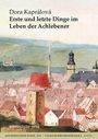"Dora Kaprálová: Erste und letzte Dinge im Leben der Achlebener." Eine Illustration einer Stadtansicht mit Kirchtürmen.