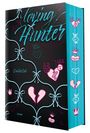 "Loving Hunter", "Emilia Cole", "roman". Schwarze Oberfläche mit blauem Muster, rosa und blaue Herz- und Totenkopf-Illustrationen.