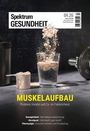 "Spektrum Gesundheit 04.26" oben. "MUSKELAUFBAU" in Gelb darunter. Proteinpulver fällt in ein Glas Wasser, daneben eine Hantel.