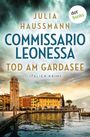 "Commissario Leonessa: Tod am Gardasee" von Julia Haussmann. Ein Hafen mit Gebäuden und einem Turm unter bewölktem Himmel.