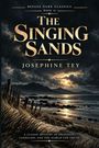 "The Singing Sands" von Josephine Tey. Strand bei Sonnenuntergang, Berge im Hintergrund, mystische Atmosphäre.