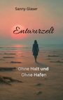 "Sanny Glaser, Entwurzelt: Ohne Halt und Ohne Hafen." Eine Person in Mantel geht bei Sonnenuntergang am Strand entlang.