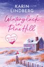 Texts: "Karin Lindberg", "Winterglück in Pine Hill", "Roman", "Seaside Kisses" (in Herzform). 

Ein schneebedecktes Haus an der Küste bei Sonnenaufgang.