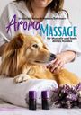 Aroma-Massage für Hunde: Ein Hund auf Handtuch, zwei violette Fläschchen, Lavendel, streichelnde Hände im Hintergrund.