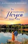 „Katharina Burkhardt. In meinem Herzen nur du.“ Zwei Personen umarmen sich an einem See bei Sonnenuntergang.