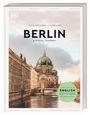 "Berlin: A Visual Journey, English Edition." Ein historisches Gebäude mit Kuppel an einem Fluss, im Hintergrund Wolken.