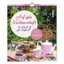 „Auf gute Nachbarschaft 2027“, „Mit 12 Postkarten“. Ein Tisch im Garten mit Muffins und rosa Geschirr.