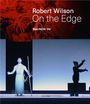 "Robert Wilson On the Edge Margery Arent Safir Editor" Szene mit beleuchtetem Mann und Person in dunkler Kleidung.