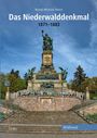 "Das Niederwalddenkmal 1871-1883, Bernd-Michael Neese." Eine große Statue mit Treppen, Menschen sitzen davor, umgeben von Bäumen.