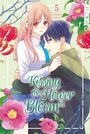 „Kissing the Flower in Bloom“, Samako Natsu. Ein Mädchen umarmt einen Jungen, umgeben von blühenden Blumen.
