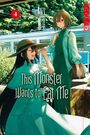 Aufschrift: „This Monster Wants to Eat Me“. Zwei Frauen in eleganter Kleidung vor einem vorbeifahrenden Zug, sonnig, grün.