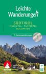Leichte Wanderungen Südtirol. Malerische Berge mit grünen Feldern und einem Dorf im Vordergrund. ROTHER-Logo links.