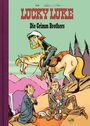 „Lucky Luke, Die Grimm Brothers“ in roter und schwarzer Schrift. Illustration mit Cowboy, Pferd, zwei Herren und Picknick.