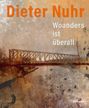 Dieter Nuhr: Woanders ist überall. Eine Brücke über einem Fluss, in warmen, erdigen Farbtönen.