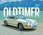 Text: "OLDTIMER 2027". Ein cremeweißer Oldtimer-Porsche mit blauer Rennstreifen steht vor einem See und Bergen.