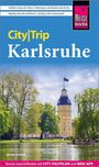 "City|Trip Karlsruhe" in gelb-weißer Schrift auf blauem Hintergrund. Im Vordergrund ein Schloss und grüner Park.