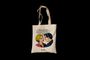 "Liebling, du weißt, ich reise nur First Class." Illustration eines Paars im Pop-Art-Stil auf einer Stofftasche.