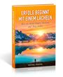 Buchtitel: "ERFOLG BEGINNT MIT EINEM LÄCHELN". Darunter: "Wie du deine innere Stimme auf Sieg stellst". Szene: Berge und See bei Sonnenuntergang.