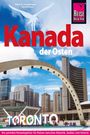 "Kanada der Osten" in Rot und Weiß, mit "TORONTO" in großen Buchstaben. Skyline mit blauem Himmel und modernen Gebäuden.