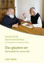 Anselm Grün, David Steindl-Rast: "Das glauben wir". Zwei Männer, auf einem Holzschreibtisch sitzend, im Gespräch.