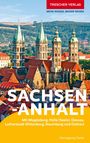 "Trescher Verlag, MEHR WISSEN. BESSER REISEN. SACHSEN-ANHALT, Mit Magdeburg ... Naumburg und Ostharz. Heinzgeorg Oette."  
Im Hintergrund sind historische Gebäude mit hohen Türmen, eingebettet in eine hügelige Landschaft, zu sehen.