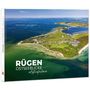 „RÜGEN OSTSEEBLICKE Luftaufnahmen“. Luftaufnahme einer Küste mit blauem Meer und grünen Feldern.