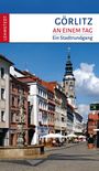 Titel: "Görlitz an einem Tag – Ein Stadtrundgang". Eine belebte Straße in Görlitz, rechts ein Uhrturm, links ein Brunnen.