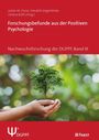 „Forschungsbefunde aus der Positiven Psychologie“, Hände halten einen kleinen Baum auf unscharfem grünem Hintergrund.