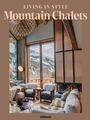 „Living in Style Mountain Chalets“ steht oben. Gemütlicher Raum mit Kamin, Holzdetails und Blick auf schneebedeckte Berge.