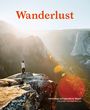 „Wanderlust“ in roter Schrift. Darunter Berge im Sonnenlicht mit einer Person auf einem Felsvorsprung.