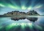 ISLAND 2027, Limited Edition. Nordlichter über Berglandschaft spiegeln sich im Wasser.