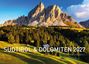"SÜDTIROL & DOLOMITEN 2027 Limited Edition." Eine beeindruckende Berglandschaft mit vielen Bäumen und einem kleinen Haus.
