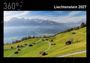 360°, Liechtenstein 2027. Eine bergige Landschaft mit kleinen Hütten auf grünen Hügeln und einem gewundenen Pfad.