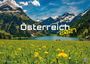 Text: "Österreich 2021". Eine idyllische Alpenszene mit grüner Wiese, gelben Blumen, Bergen und einem See.