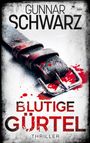 „GUNNAR SCHWARZ, BLUTIGE GÜRTEL, THRILLER“. Ein blutiger Ledergürtel mit Schnalle auf weißem Untergrund.
