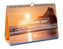 "Life is More 2027, Panoramakalender" in weißen Buchstaben. Surfer im Meer bei Sonnenuntergang.