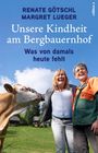 Zwei Mädchen sitzen auf einer Wiese, eins hält ein Kätzchen, das andere ein Kätzchen.