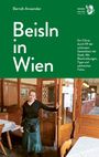 „Beisln in Wien“ – Ein Restaurantführer. Eine Frau steht lächelnd in einem traditionellen Lokal mit Holzinterieur.