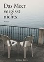 „Das Meer vergisst nichts. Roman. Arthur Kern.“ Zwei Stühle vor einem Geländer, Blick auf das Meer. Ein Handy auf einem Stuhl.