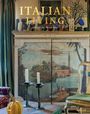 Text: "Italian Living, Guillaume de Laubier".  
Ein rustikales Interieur mit Gemälde, Kerzenhaltern und Kürbis.