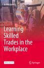 "Learning Skilled Trades in the Workplace" steht in großen weißen Buchstaben. Ein Schweißer mit dekoriertem Helm arbeitet.